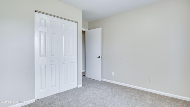 unfurnished bedroom with carpet flooring and a closet