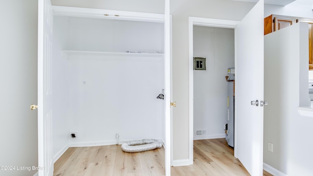 clothes washing area with light hardwood / wood-style floors