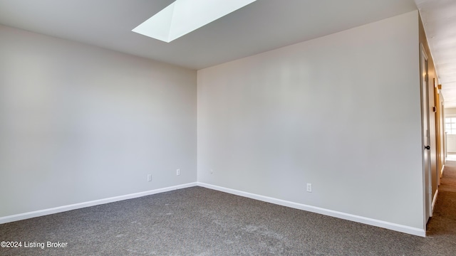 carpeted empty room with a skylight