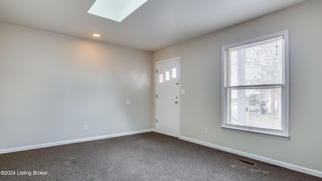 carpeted entrance foyer with a skylight and a healthy amount of sunlight