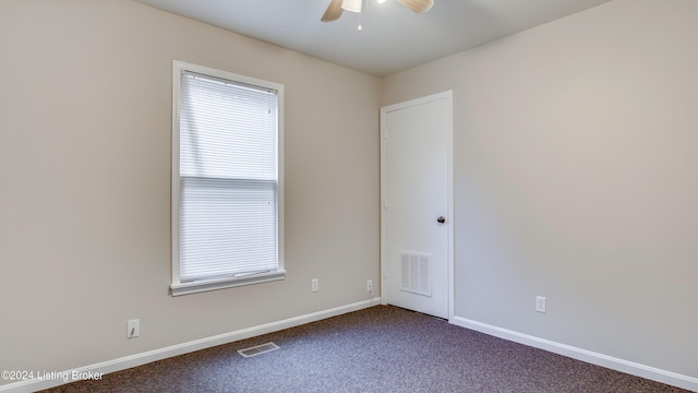 spare room with ceiling fan and carpet