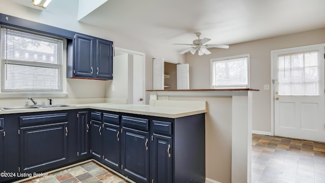 kitchen with ceiling fan, blue cabinets, sink, and kitchen peninsula