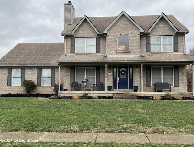 view of front of house with covered porch and a front lawn