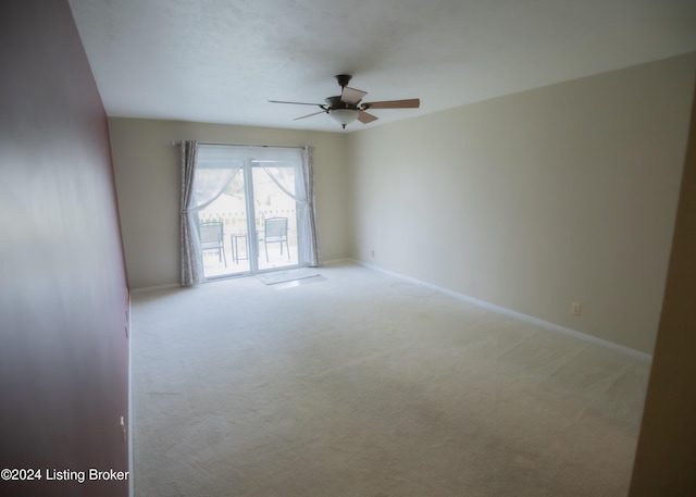 spare room featuring light colored carpet and ceiling fan