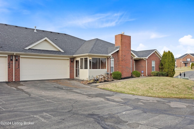 view of front of property with a front yard and a garage