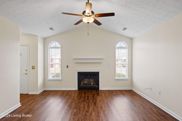 unfurnished living room featuring a textured ceiling, ceiling fan, dark wood-type flooring, and vaulted ceiling