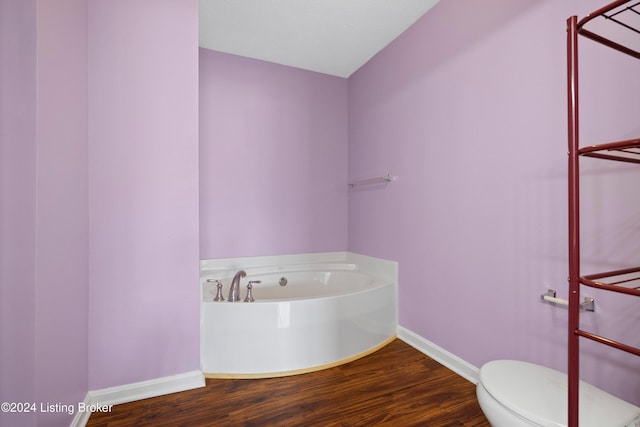 bathroom featuring hardwood / wood-style floors, a bathtub, and toilet