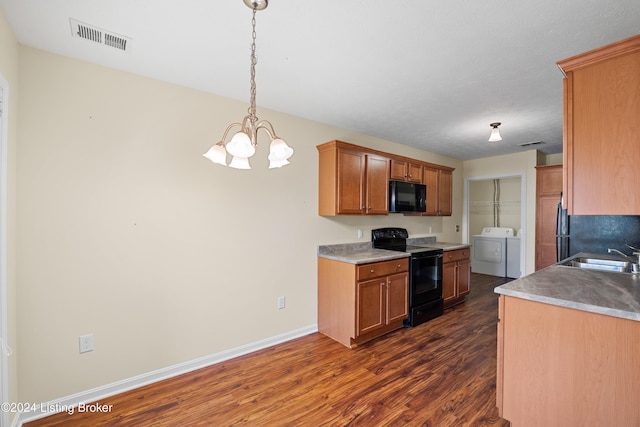 kitchen with black appliances, sink, separate washer and dryer, dark hardwood / wood-style flooring, and a chandelier