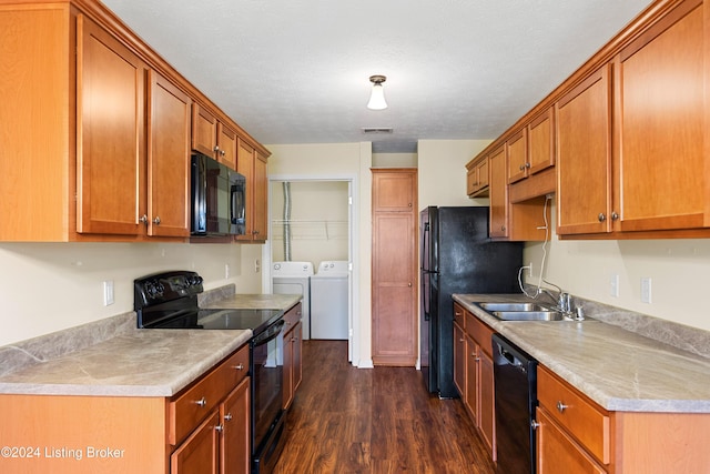 kitchen featuring a textured ceiling, sink, black appliances, washing machine and dryer, and dark hardwood / wood-style floors