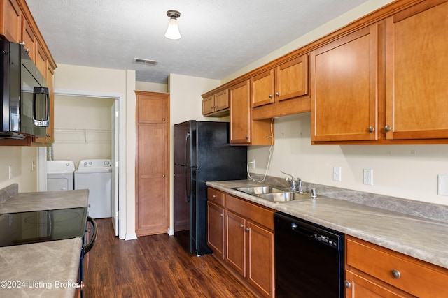 kitchen featuring sink, dark hardwood / wood-style flooring, independent washer and dryer, a textured ceiling, and black appliances