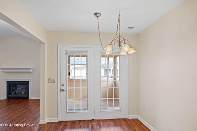 doorway featuring dark wood-type flooring and an inviting chandelier