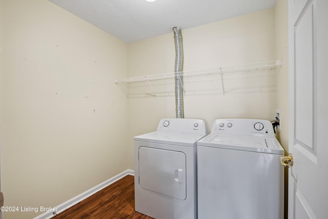 clothes washing area featuring dark wood-type flooring and washing machine and clothes dryer