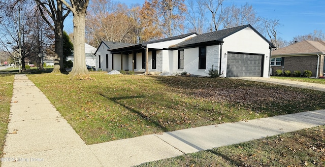 view of front of property with a garage and a front lawn