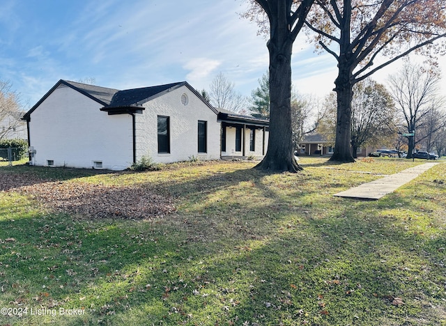 view of side of home with a yard