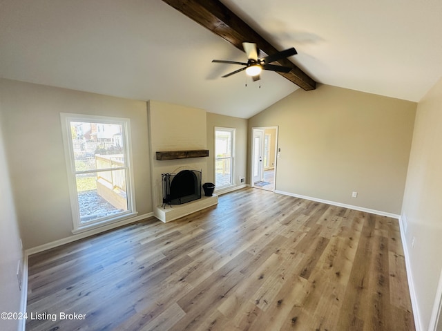 unfurnished living room with vaulted ceiling with beams, light hardwood / wood-style floors, ceiling fan, and a large fireplace