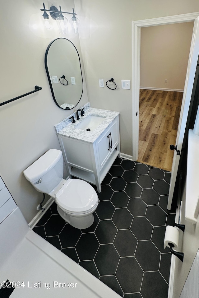 bathroom featuring wood-type flooring, vanity, and toilet