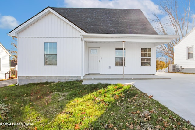 view of front of property featuring central AC, covered porch, and a front yard