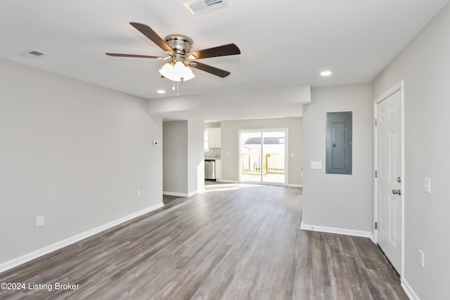 unfurnished living room with dark hardwood / wood-style flooring, electric panel, and ceiling fan