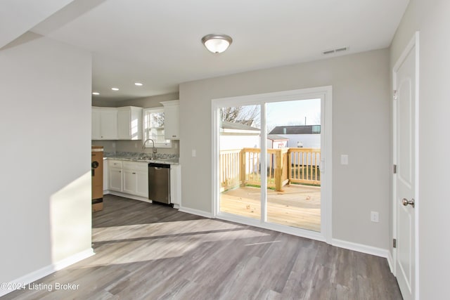 kitchen featuring stainless steel dishwasher, dark hardwood / wood-style floors, white cabinetry, and sink