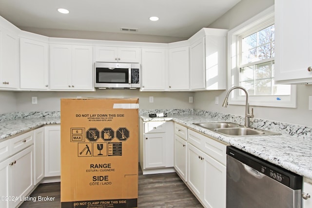 kitchen with dark wood-type flooring, sink, white cabinets, and stainless steel appliances