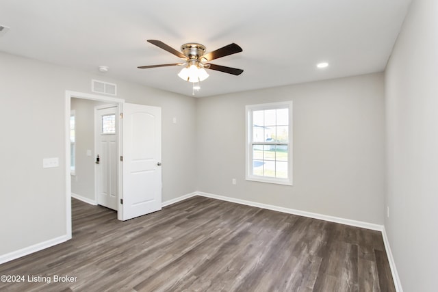 empty room with ceiling fan and dark wood-type flooring