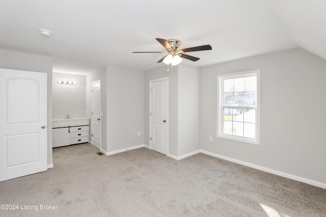 unfurnished bedroom featuring light carpet, ceiling fan, and lofted ceiling