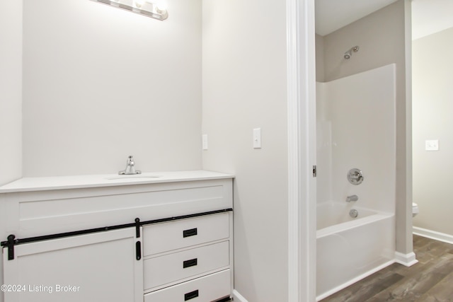 bathroom with vanity, wood-type flooring, and  shower combination