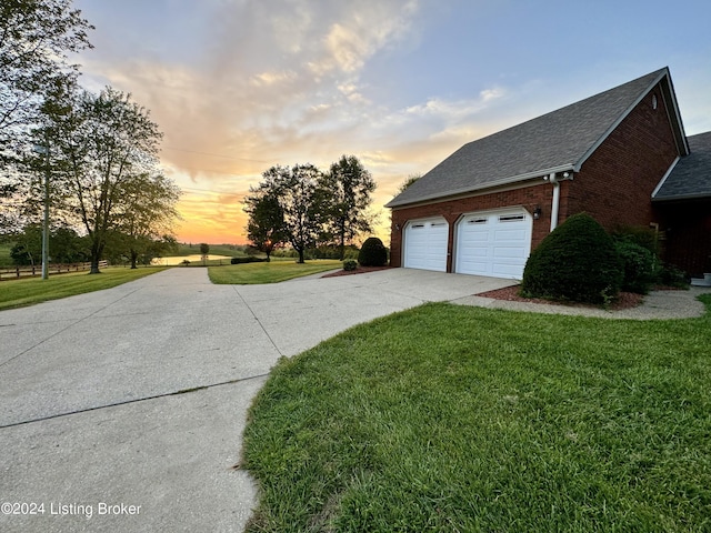 property exterior at dusk with a yard and a garage