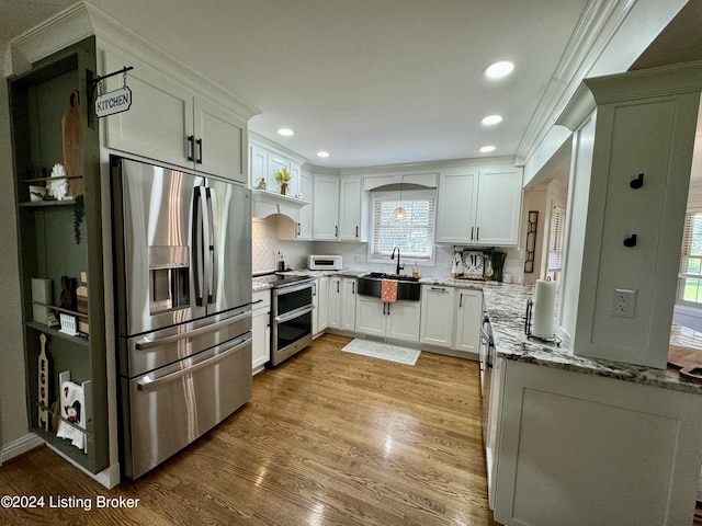 kitchen with appliances with stainless steel finishes, light wood-type flooring, stone countertops, and white cabinetry