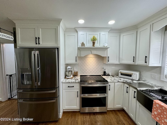 kitchen with white cabinets, decorative backsplash, dark wood-type flooring, and appliances with stainless steel finishes