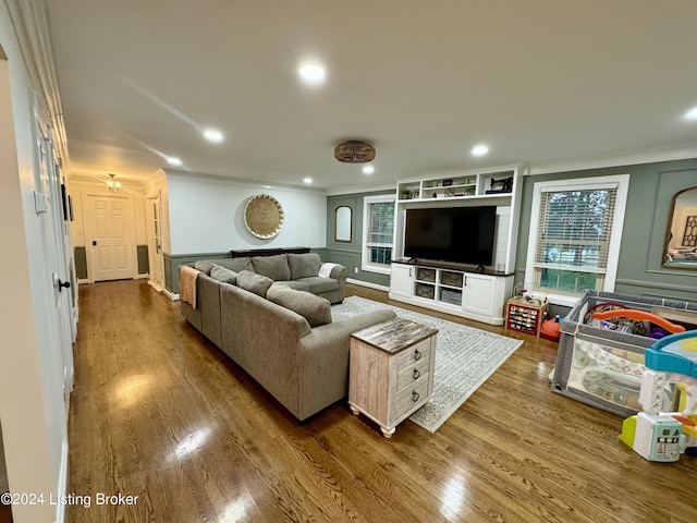 living room with wood-type flooring and ornamental molding