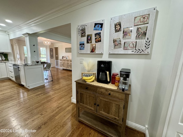 hallway featuring light hardwood / wood-style floors and ornamental molding