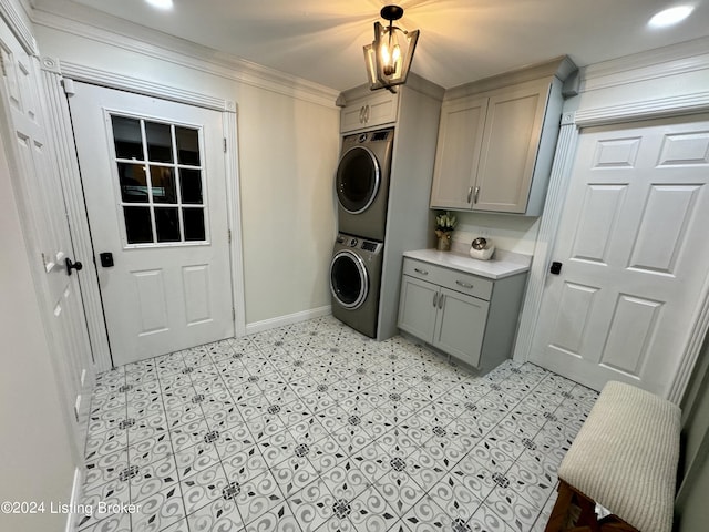 clothes washing area with stacked washer / drying machine, cabinets, and ornamental molding