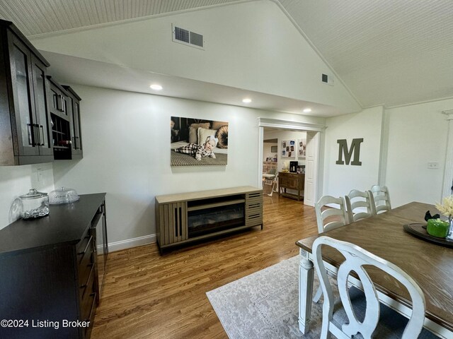 dining room with dark hardwood / wood-style floors and high vaulted ceiling