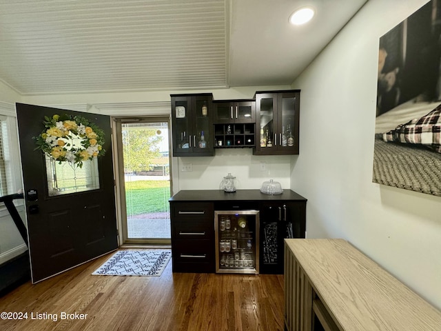 bar with dark hardwood / wood-style floors and beverage cooler