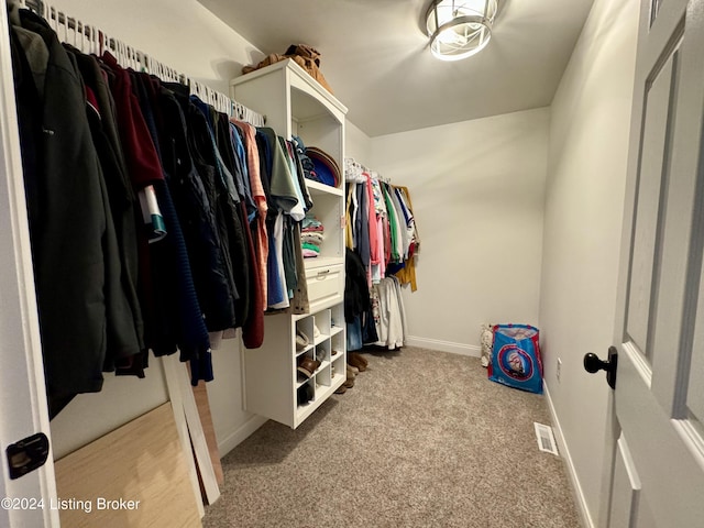 walk in closet featuring light carpet