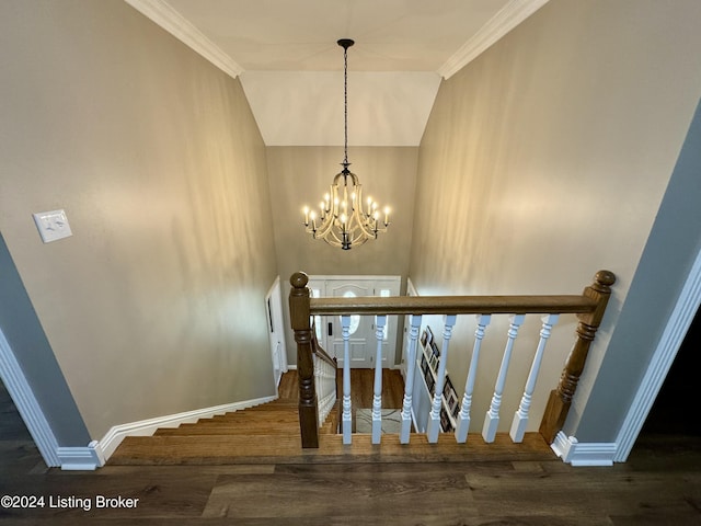 staircase featuring crown molding, hardwood / wood-style floors, and a notable chandelier