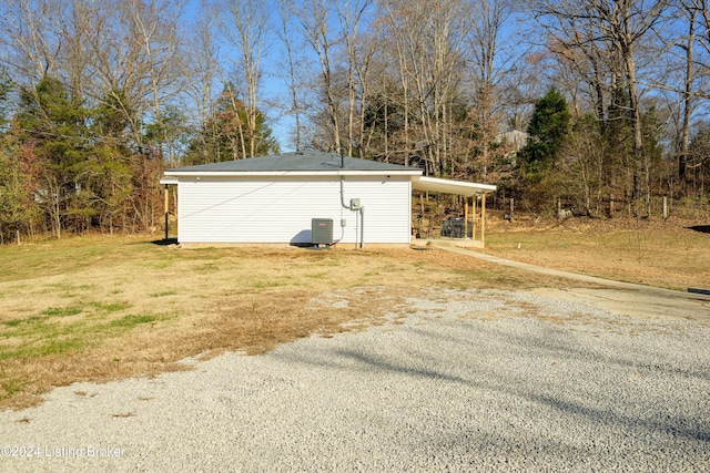 view of home's exterior with a carport, central AC unit, and a yard