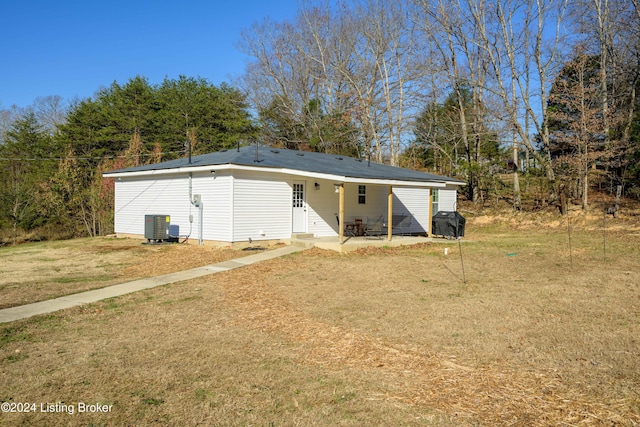 back of property featuring a patio, a yard, and central AC