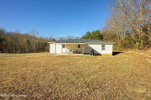 rear view of property featuring a yard and a patio