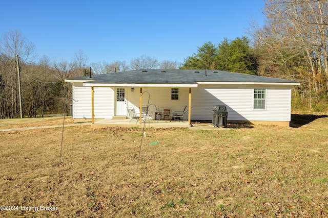 rear view of house with a yard and a patio