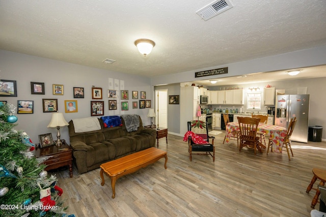 living room with light hardwood / wood-style floors and a textured ceiling