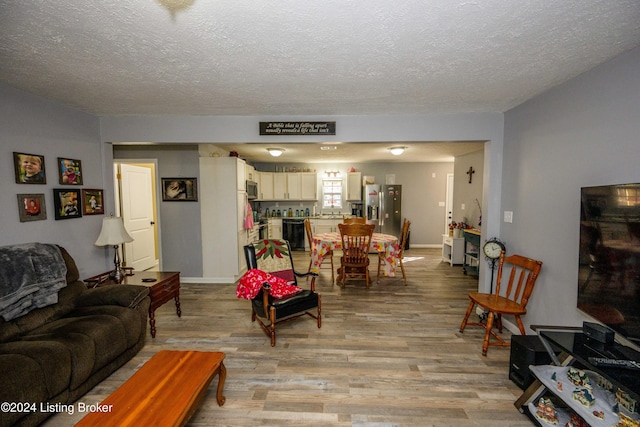 living room featuring a textured ceiling and light wood-type flooring