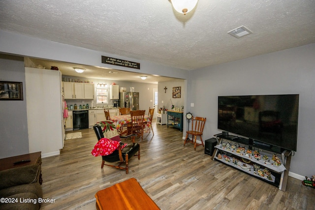 living room featuring light hardwood / wood-style floors and a textured ceiling