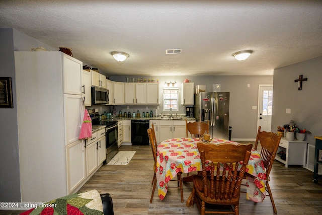 kitchen with hardwood / wood-style floors, stainless steel appliances, and a healthy amount of sunlight