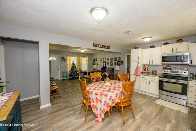 dining room featuring hardwood / wood-style floors and a textured ceiling