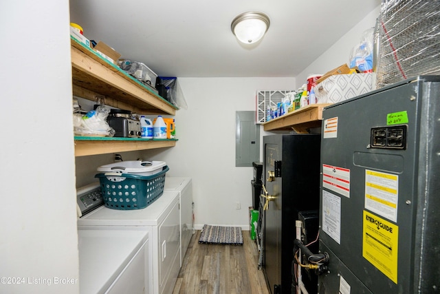 laundry room featuring wood-type flooring, washing machine and dryer, and electric panel