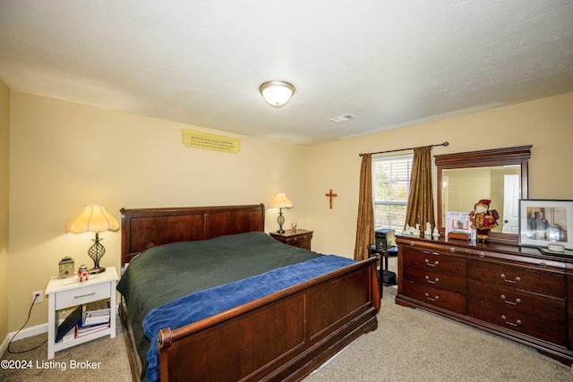 bedroom featuring a textured ceiling and light colored carpet