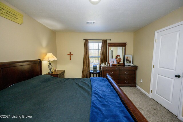 carpeted bedroom featuring a textured ceiling