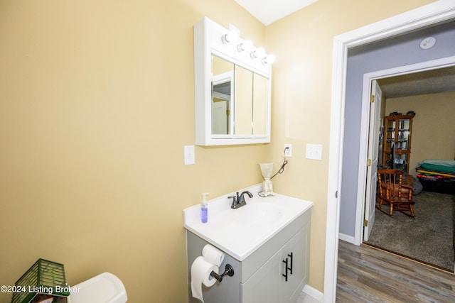 bathroom featuring toilet, vanity, and hardwood / wood-style flooring